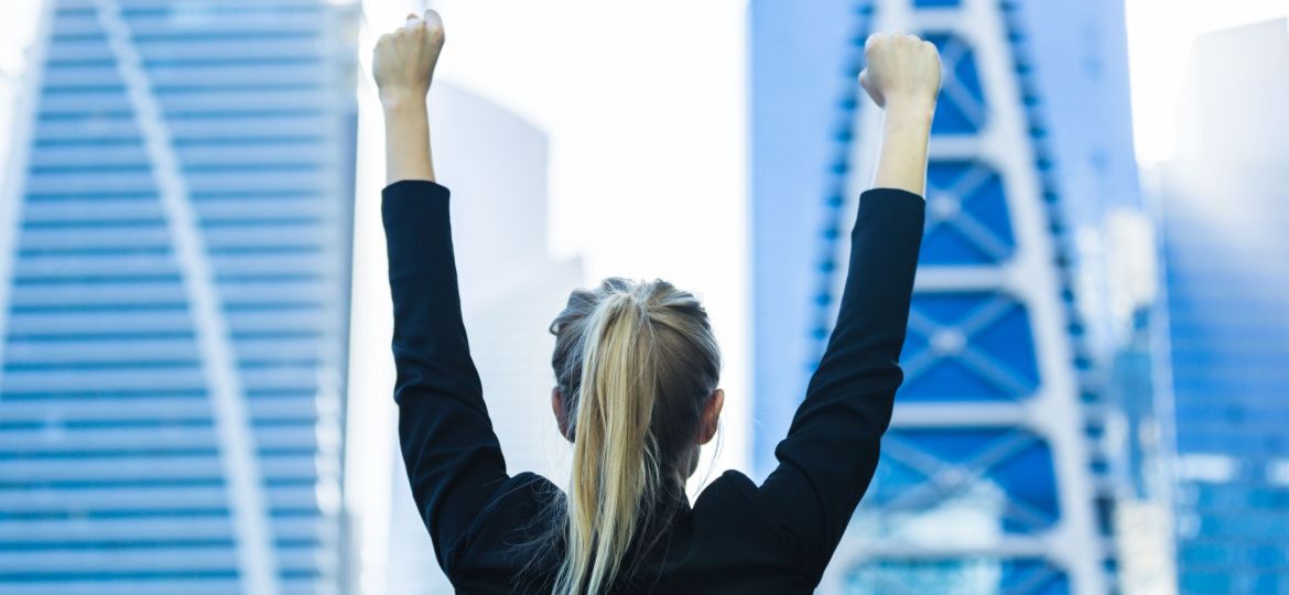 Business,Success,-,Celebrating,Businesswoman,Overlooking,The,City,Center,High-rises.