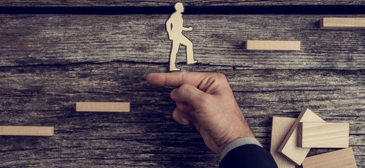 Businessman,Supporting,Paper,Cut,Out,Of,A,Man,Climbing,Stairs,